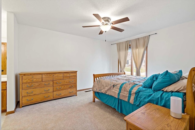bedroom featuring baseboards, a ceiling fan, a textured ceiling, and light carpet