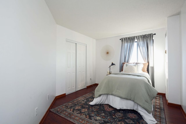 bedroom with dark hardwood / wood-style floors and a closet