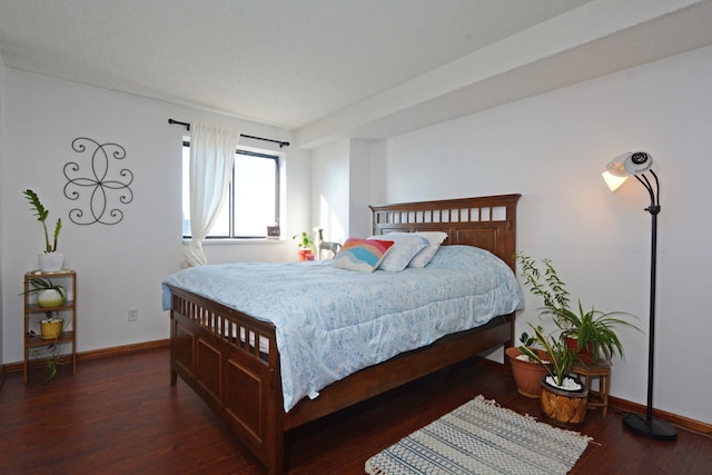 bedroom with dark hardwood / wood-style floors