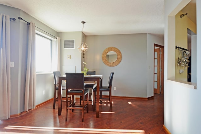 dining area with dark hardwood / wood-style flooring and a textured ceiling