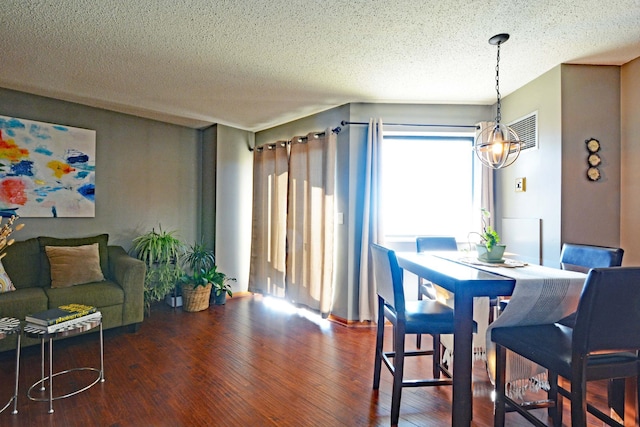 dining area featuring hardwood / wood-style flooring and a textured ceiling