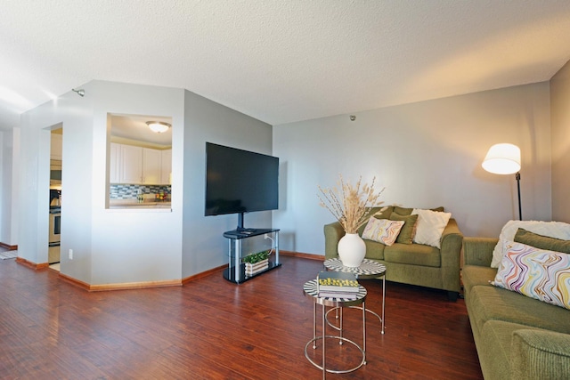 living room with a textured ceiling, baseboards, and wood finished floors