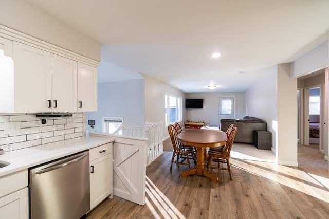 kitchen featuring stainless steel dishwasher, light hardwood / wood-style floors, and white cabinets