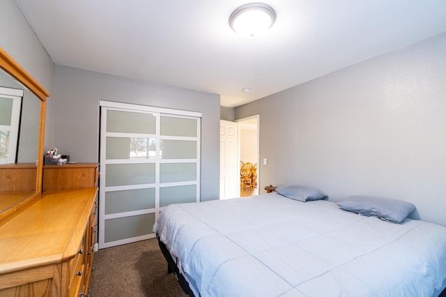 bedroom with dark carpet and a closet