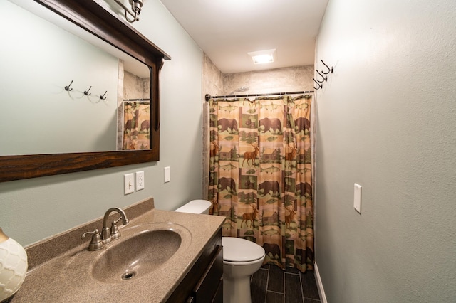 bathroom with vanity, toilet, and walk in shower