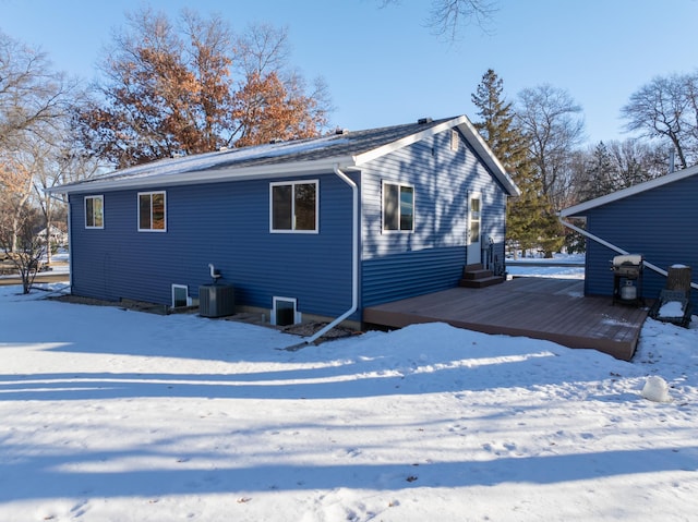 snow covered property with a wooden deck and central air condition unit