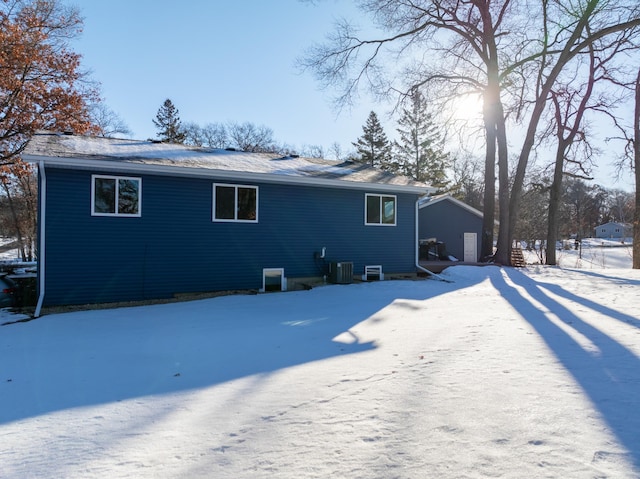 snow covered back of property with cooling unit