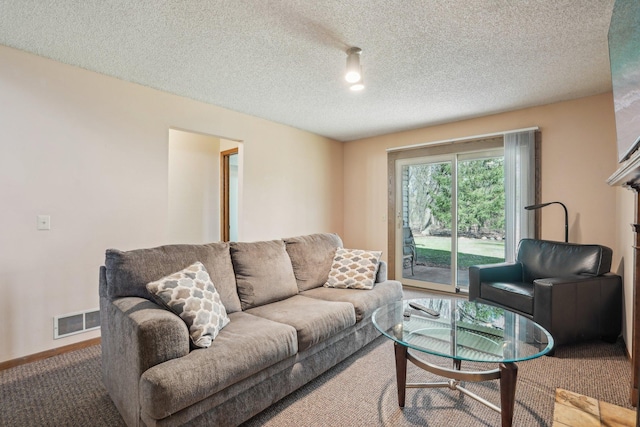 carpeted living room with visible vents and a textured ceiling