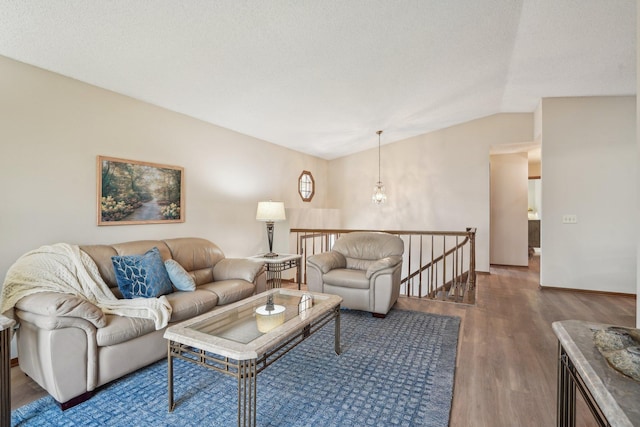 living area featuring vaulted ceiling, wood finished floors, and baseboards