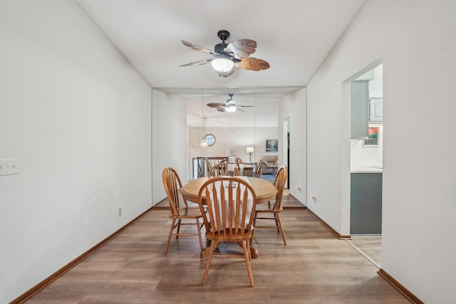 dining area with light wood finished floors, baseboards, and ceiling fan