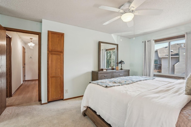 bedroom with a ceiling fan, baseboards, multiple windows, and light colored carpet