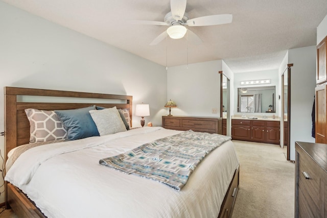 bedroom featuring ceiling fan, ensuite bath, and light carpet