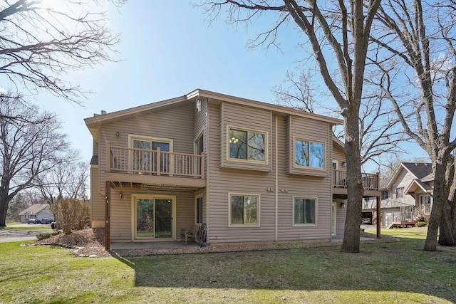 back of house with a yard and a balcony