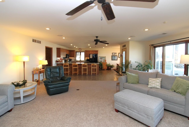 living area featuring visible vents, recessed lighting, and carpet