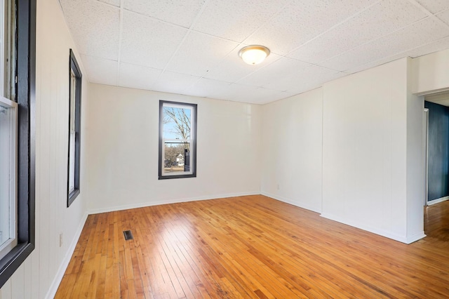 spare room featuring hardwood / wood-style flooring and a paneled ceiling