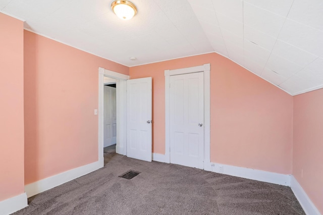 additional living space featuring vaulted ceiling and carpet floors