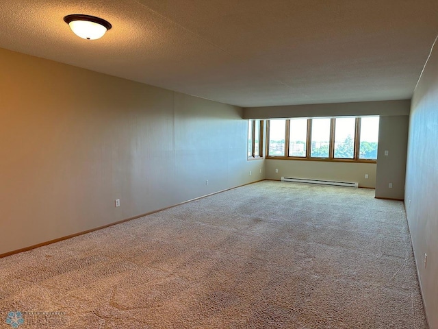 carpeted spare room featuring a textured ceiling and baseboard heating