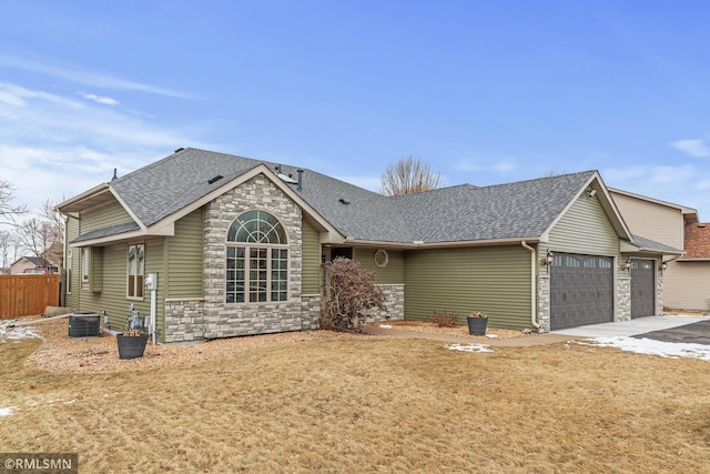 view of front of house featuring central AC unit, a garage, and a front lawn