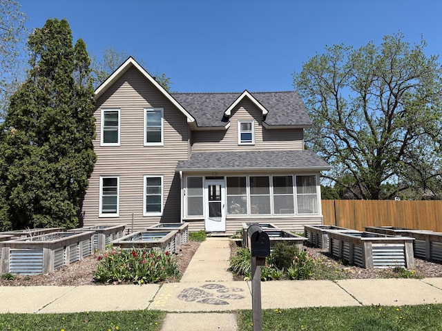 20 1st Ave NW, Plainview, MN 55964 - view of front of house with a garden, a sunroom, a shingled roof, and fence
