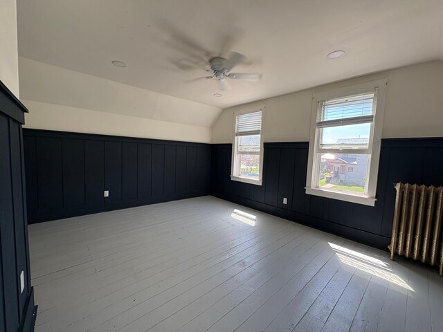 20 1st Ave NW, Plainview, MN 55964 - additional living space with radiator heating unit, ceiling fan, vaulted ceiling, light wood finished floors, and a wainscoted wall