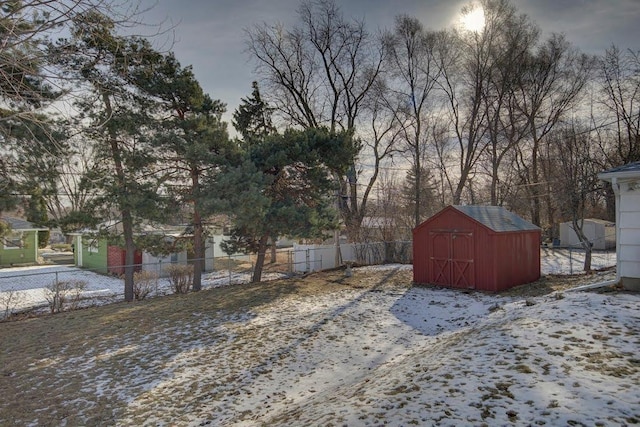 yard layered in snow with a storage shed