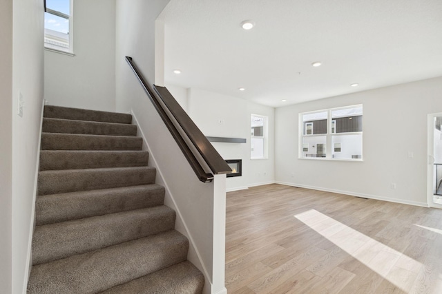 staircase with hardwood / wood-style flooring