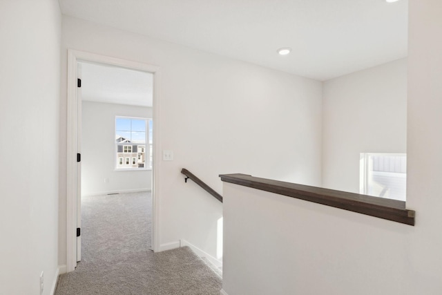 hall with light colored carpet