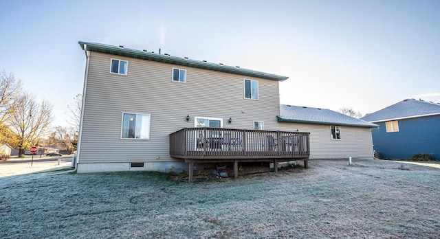 rear view of property with a wooden deck and a lawn