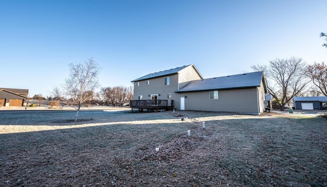 rear view of property with a yard and a deck