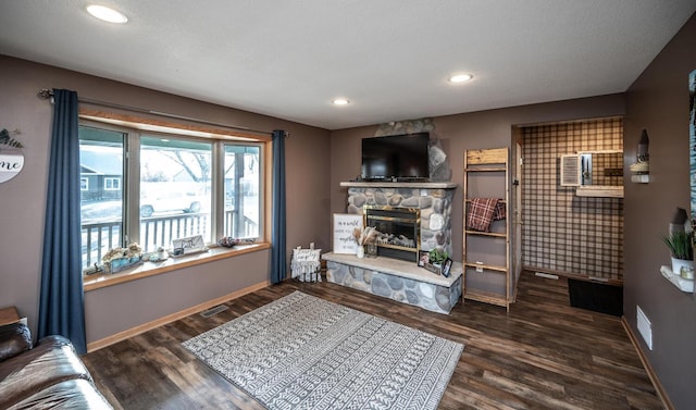 living room with a stone fireplace and dark wood-type flooring