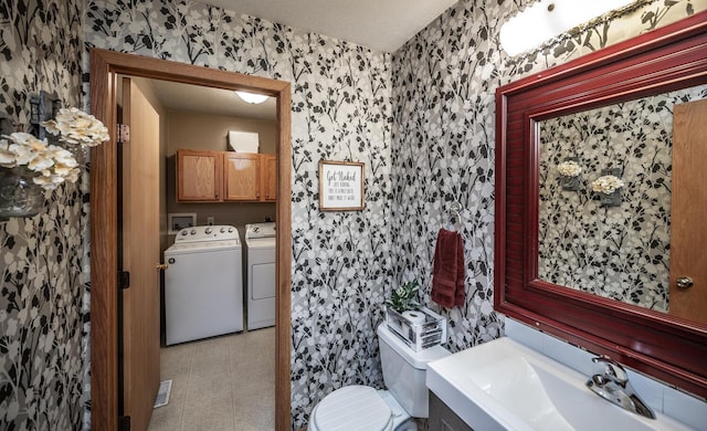 bathroom featuring vanity, independent washer and dryer, and toilet