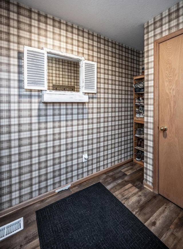 entrance foyer featuring dark wood-type flooring and a textured ceiling