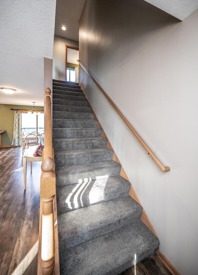 stairway featuring hardwood / wood-style flooring and a textured ceiling