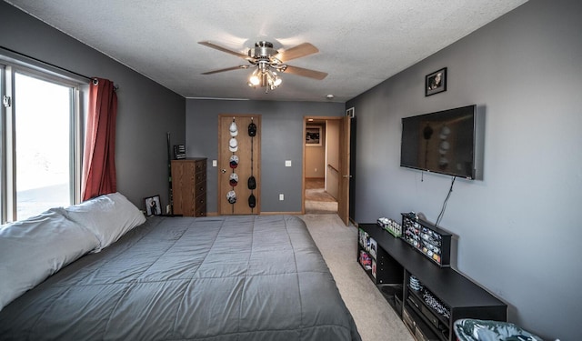 bedroom with ceiling fan, a textured ceiling, and carpet