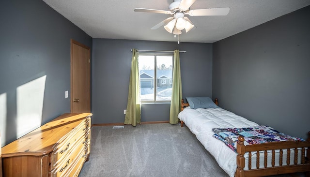 carpeted bedroom featuring a textured ceiling and ceiling fan