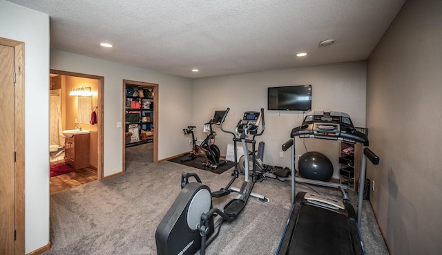 exercise room with sink and a textured ceiling