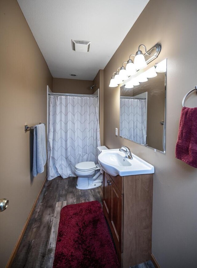 bathroom featuring vanity, wood-type flooring, and toilet