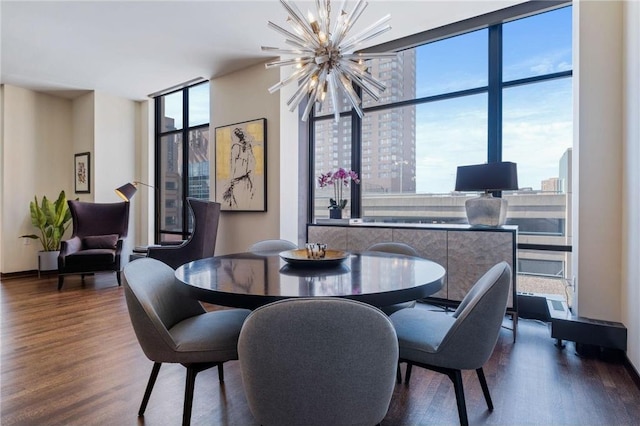 dining space featuring hardwood / wood-style flooring, a chandelier, and a wall of windows