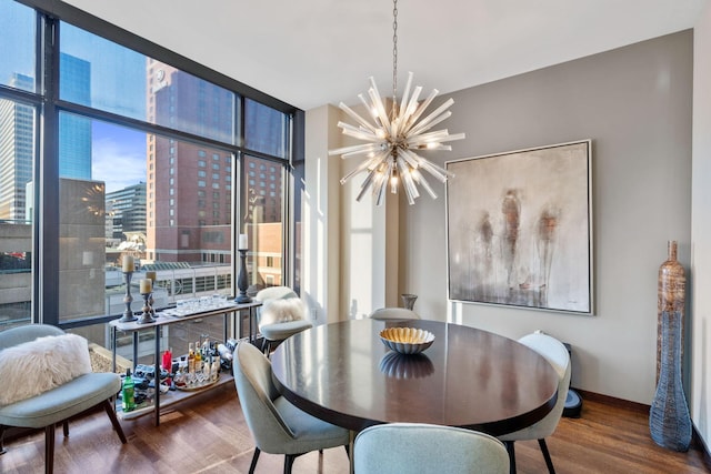 dining area featuring an inviting chandelier, a wall of windows, and hardwood / wood-style floors