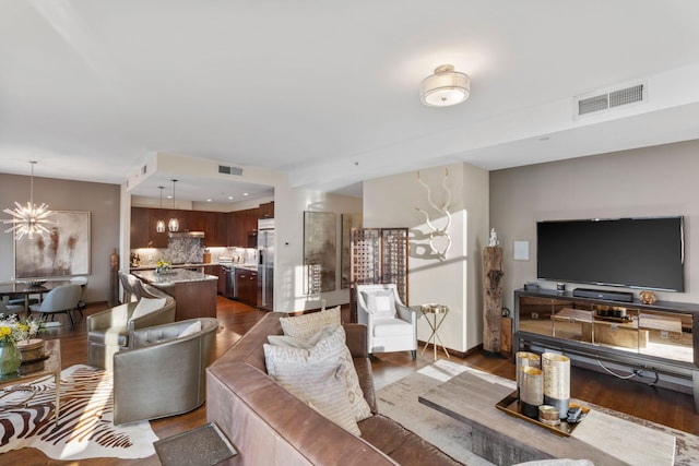 living room with dark hardwood / wood-style floors and a chandelier