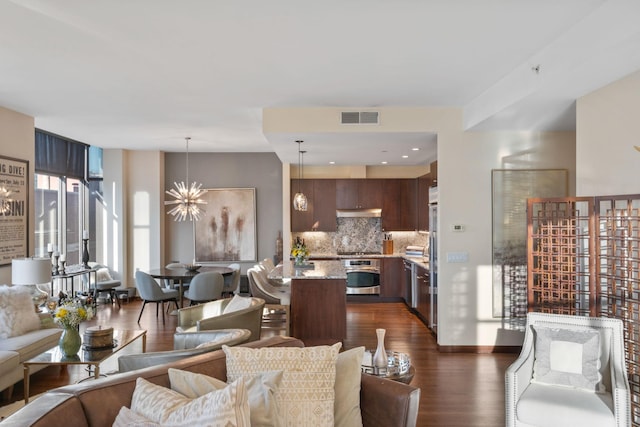 living room featuring dark wood-type flooring and a notable chandelier