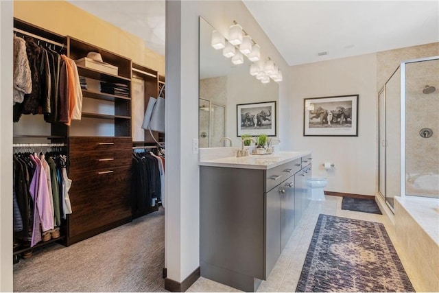 bathroom featuring vanity, tile patterned floors, toilet, and walk in shower