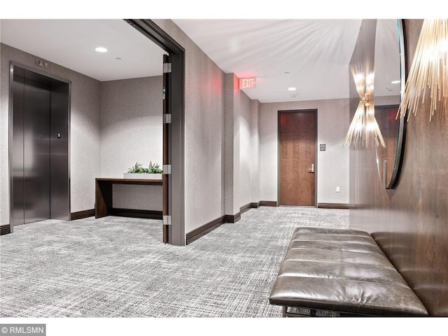 hallway with elevator and carpet