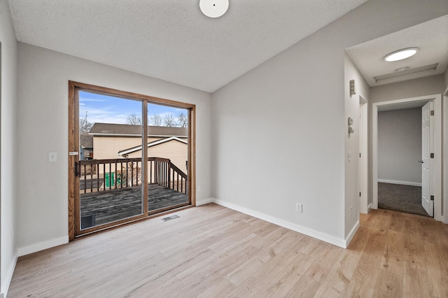 unfurnished room with a textured ceiling, baseboards, visible vents, and light wood-type flooring