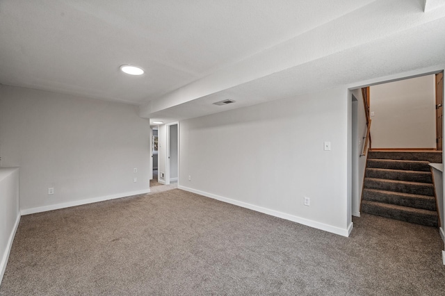 empty room featuring stairway, carpet, visible vents, and baseboards