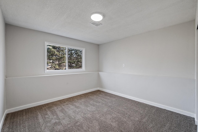 carpeted spare room with visible vents, baseboards, and a textured ceiling