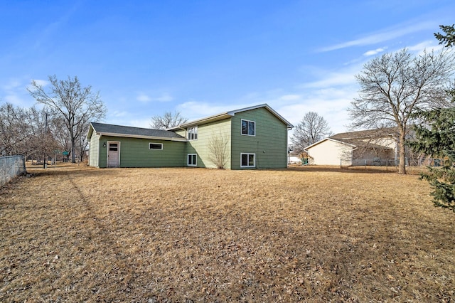 rear view of property featuring fence