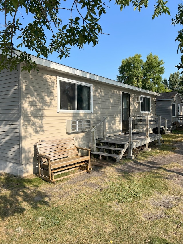 rear view of property with a deck and a lawn