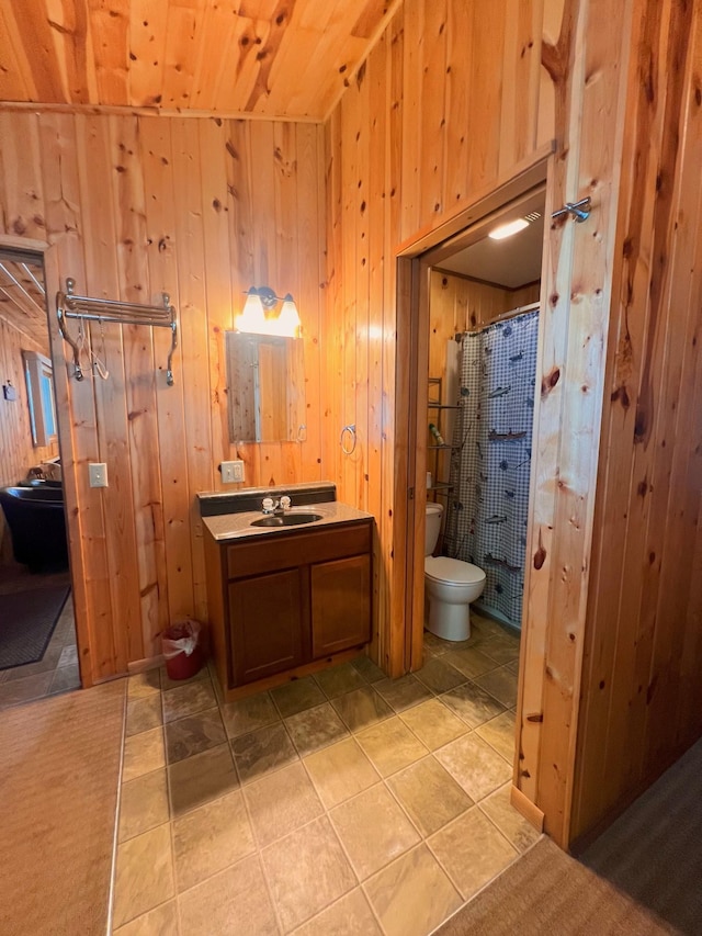 bathroom with vanity, a shower with shower curtain, wood walls, and toilet