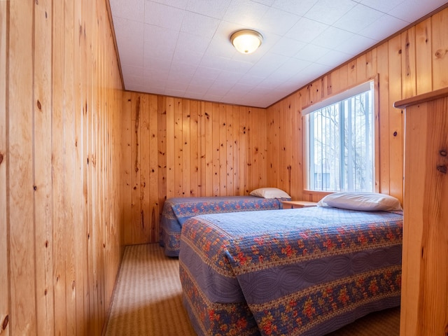 bedroom featuring carpet flooring and wood walls